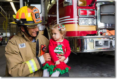 Una niña pequeña con un bombero